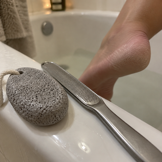 Pumice stone and foot file on the bathtub edge